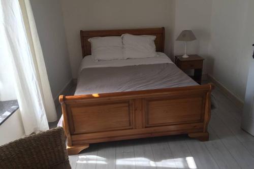 a bedroom with a bed with a wooden frame and pillows at La casa Trivala in Carcassonne