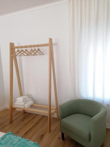 a room with a green chair and a mirror at Silver Home in Nazaré