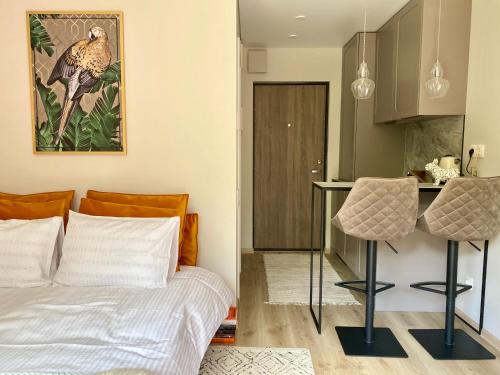 a bedroom with a bed and a table and a kitchen at Modern Studio Juodkrante in Juodkrantė