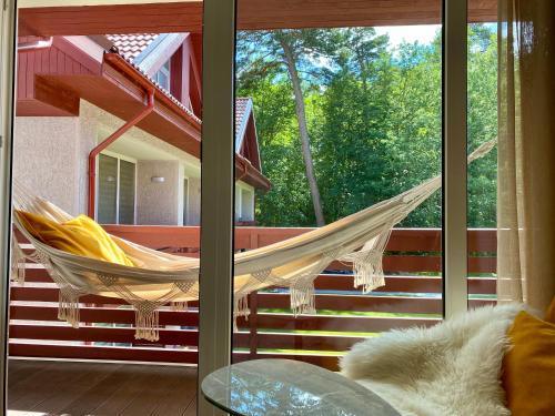a hammock on the porch of a house at Modern Studio Juodkrante in Juodkrantė