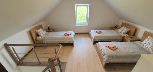 a attic room with three beds and a window at Villa Monciske in Palanga