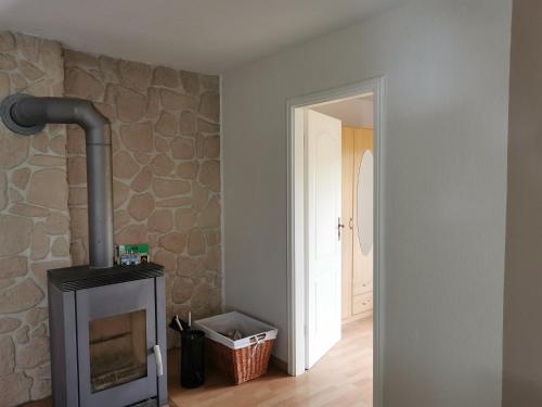a fireplace in a room with a stone wall at Ferienhaus Hase Bomsdorfer Hof in Gräfenhainichen