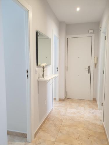 uma casa de banho branca com um espelho e um lavatório em Bianca em Valência
