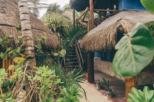 a building with a staircase and a straw hut at La Conchita Tulum in Tulum