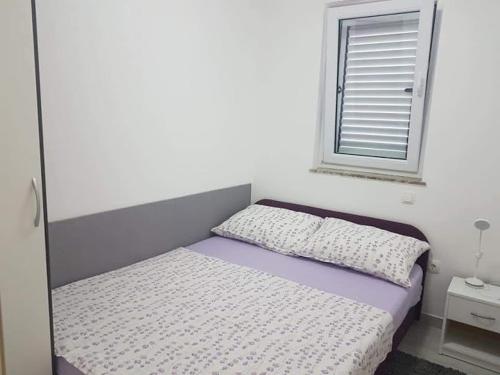 małe łóżko w pokoju z oknem w obiekcie Sabljak w mieście Kornić