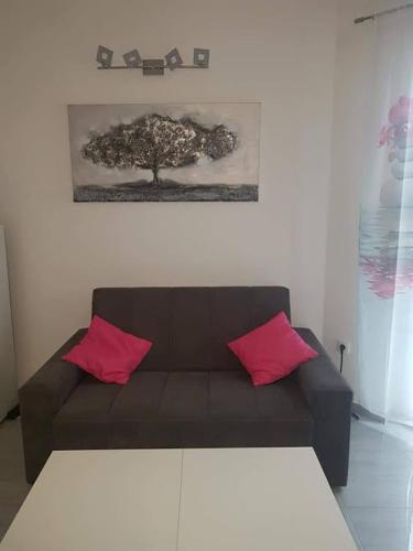 a living room with a brown couch with two pink pillows at Sabljak in Kornić