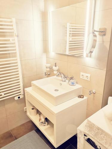 a white bathroom with a sink and a mirror at Landidyll am Thiersee in Thiersee