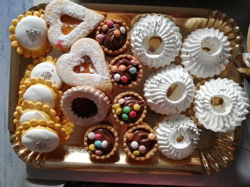 a tray filled with donuts and other pastries at viche viche in Orgosolo