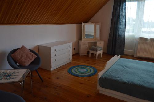 a bedroom with a bed and a chair and a dresser at Dom na Mazurach in Ostróda