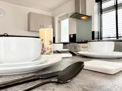 a table with white plates and spoons on it at Annexe@No8 in Haverfordwest