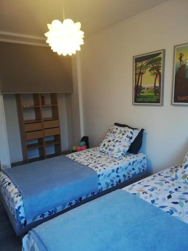 une chambre avec deux lits et un lustre dans l'établissement BEACH-CITY 3 PIECES, à Saint-Raphaël