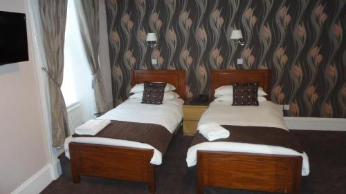 
a hotel room with two beds and two nightstands at Sandyford Lodge - Hotel West- in Glasgow
