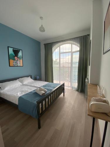 a bedroom with a bed and a large window at Hestia - Hotel, Wine and View in Tʼelavi