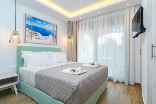 a bedroom with a bed with two towels on it at Maria Elena Suites in Limenas