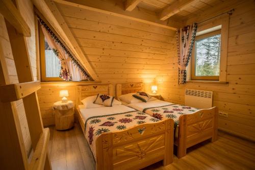 a bedroom with a bed in a log cabin at Kirowy Domek in Kościelisko