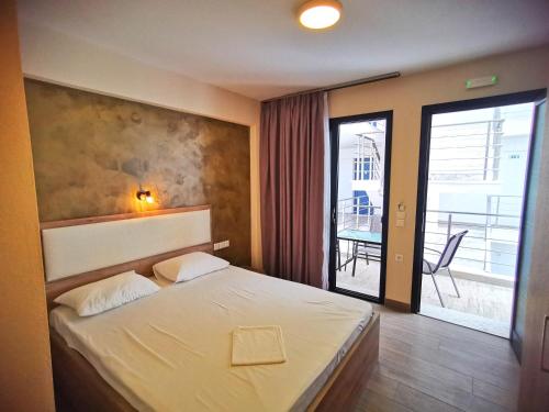 a bedroom with a bed and a balcony with a table at Sarti Holidays in Sarti
