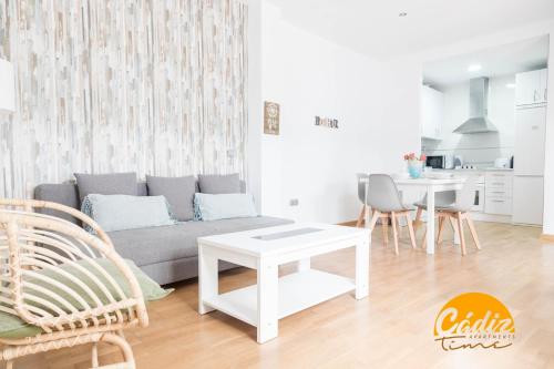 ein Wohnzimmer mit Sofa und Tisch in der Unterkunft Apartamento Caleta - FREE PARKING by Cadiz Time in Cádiz