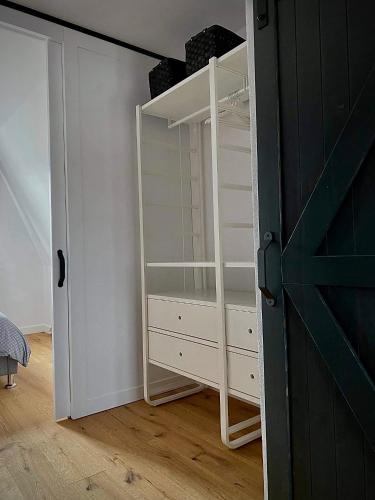 a room with a closet with a book shelf and a door at Apartmán Anna in Komárno