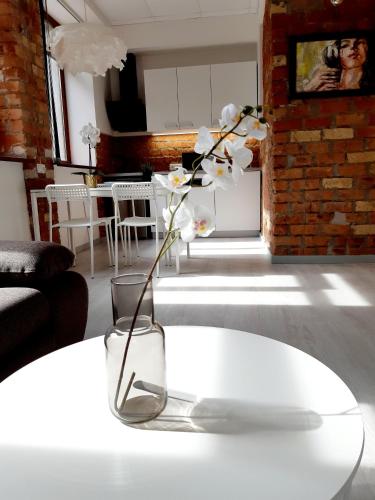 a vase with flowers sitting on a table in a living room at Apartments Daina in Jūrmala