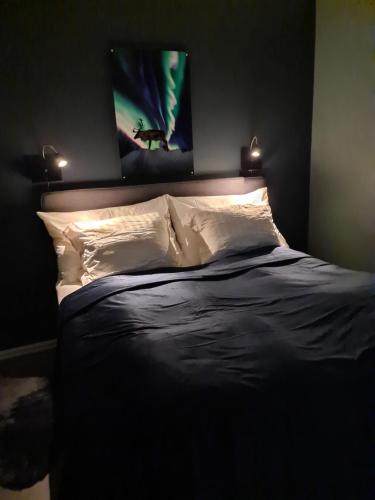 ein Schlafzimmer mit einem Bett mit zwei Leuchten in der Unterkunft Aurora Dream in Svensby