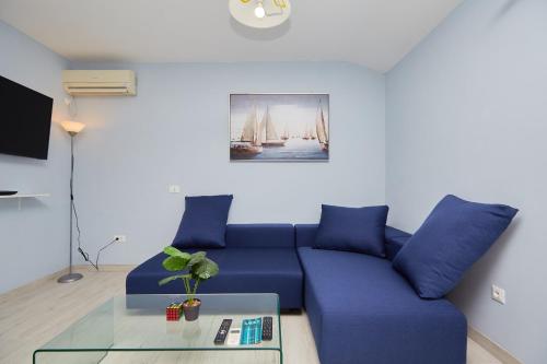 a living room with a blue couch and a table at Apartments Kolorina in Dubrovnik