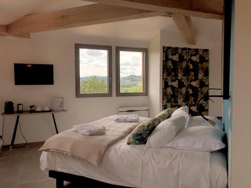 - une chambre avec un grand lit blanc et 2 fenêtres dans l'établissement Les Hauts de Gageac Maison d'Hôtes de Charme, à La Roque-Gageac