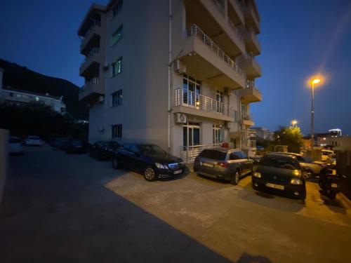 un grupo de autos estacionados en un estacionamiento al lado de un edificio en Apartment Sofija, en Budva