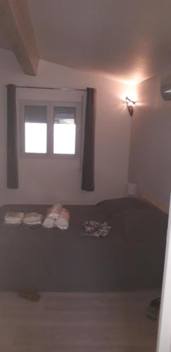 Schlafzimmer mit einem Bett und einem Fenster in der Unterkunft Maisonnette presqu ile de Giens in Hyères