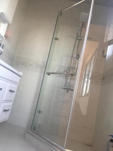um chuveiro com uma porta de vidro na casa de banho em Warm Flat em Gonio