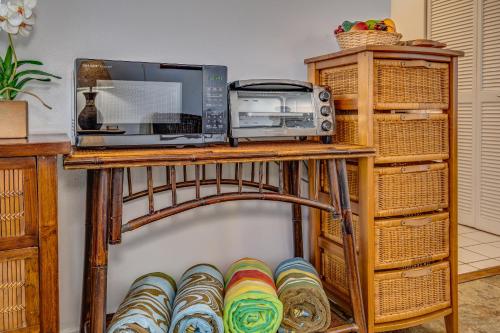 a table with a microwave and a radio and baskets at @ Marbella Lane - Breezy Studio@Diamond Head Beach Hotel in Honolulu