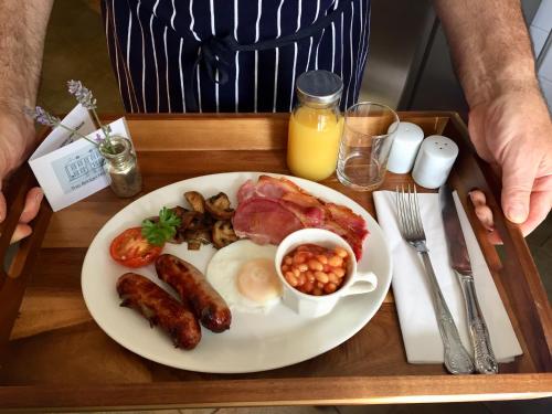 a plate of breakfast food with eggs sausage and beans at The Bridge House in Bridport