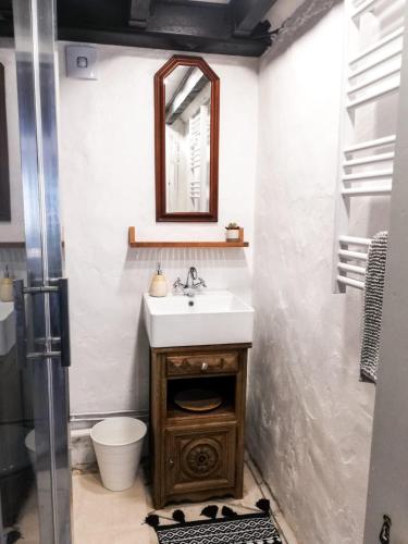 une salle de bain avec un lavabo, des toilettes et un miroir dans l'établissement Ti Baou, à Châteauneuf-du-Faou