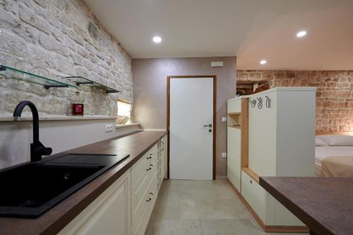 a kitchen with a sink and a white refrigerator at Villa Kudelik - Stone Story in Trogir
