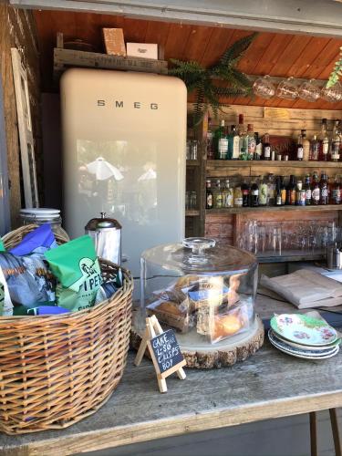a table with a basket of food and a refrigerator at The Bridge House in Bridport