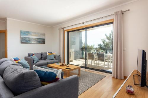 a living room with a couch and a tv at Alegria Amazing apartment with swimming pool in Olhão
