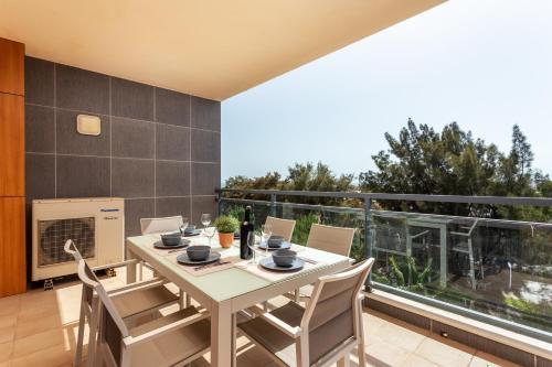 a dining room with a table and chairs on a balcony at Alegria Amazing apartment with swimming pool in Olhão