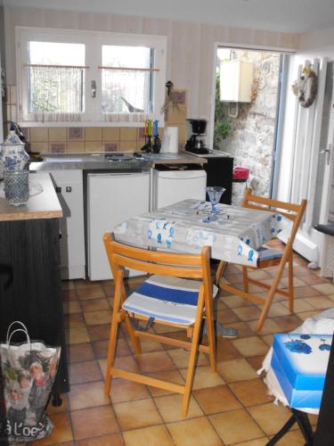 a kitchen with a table and two chairs and a table at Maisonnette Mimi in Rochefort