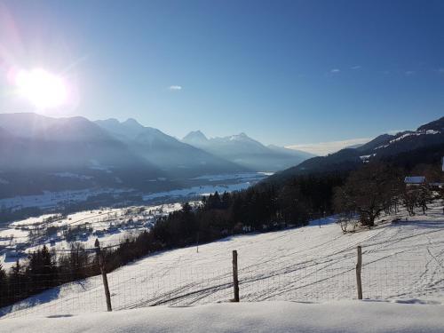a snow covered hill with the sun in the background at Ferienwohnung Wieserberg in Dellach