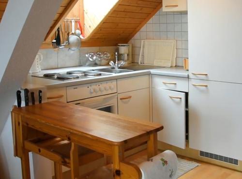 uma cozinha com uma mesa de madeira e um fogão em Ferienwohnung Wieserberg em Dellach