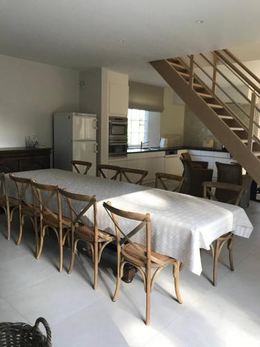 a room with a table and chairs and a kitchen at Oscaar vakantiewoning in bos in Koekelare