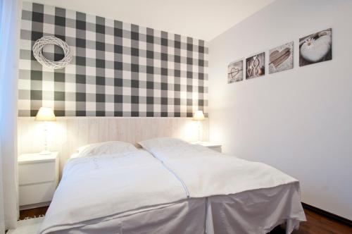 a bedroom with a bed and a checkered wall at Pokoje Pinokio in Darłowo