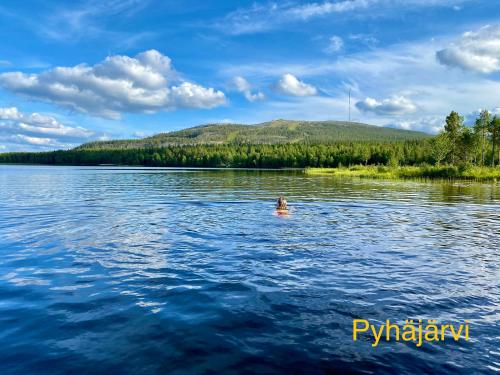 a person swimming in the water on a lake at Arctic Lodges Lapland Ski in Studio, slopes, ski tracks, National Park, free Wi-Fi - Lapland Villas in Pyhätunturi