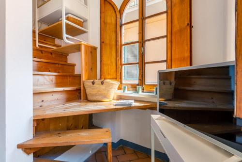 Pokój z drewnianymi półkami i oknem w obiekcie LUI Tuscany Loft w mieście San Miniato