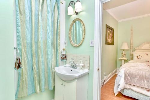 a bathroom with a sink and a bed and a mirror at Redwood Bed and Breakfast in Niagara Falls