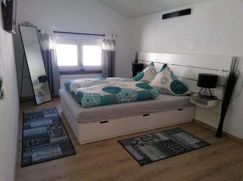 una camera da letto con letto, cuscini e specchio di Haus Monteiro a Elbigenalp