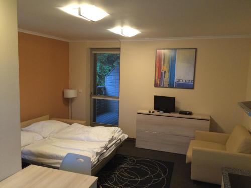 a bedroom with a bed and a desk and a window at Apartman Harrachov in Harrachov