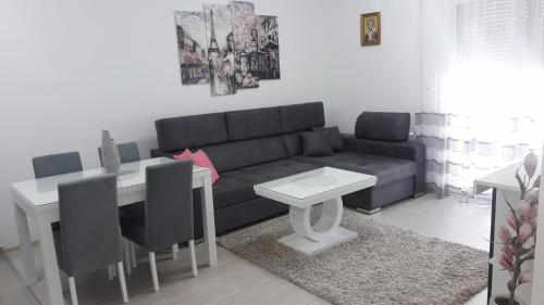 sala de estar con sofá y mesa en Renome apartmani, en Banja Koviljača