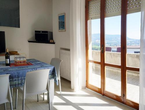 a dining room with a table with chairs and a sliding glass door at CONERO APARTMENT in Castelfidardo