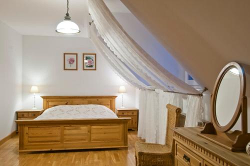 1 dormitorio con cama y espejo grande en Pokoje Pinokio, en Darłowo