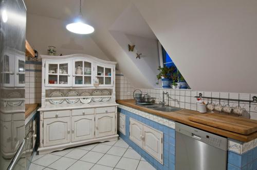 a kitchen with white cabinets and a sink at Pokoje Pinokio in Darłowo